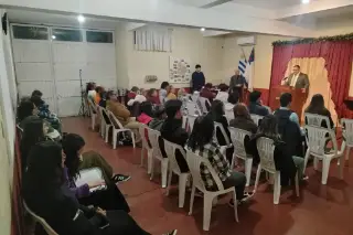 La congregación escucha al pastor, vista desde el fondo del salón.
