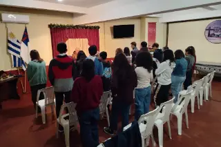 Los jóvenes de pie frente al púlpito durante la reunión.